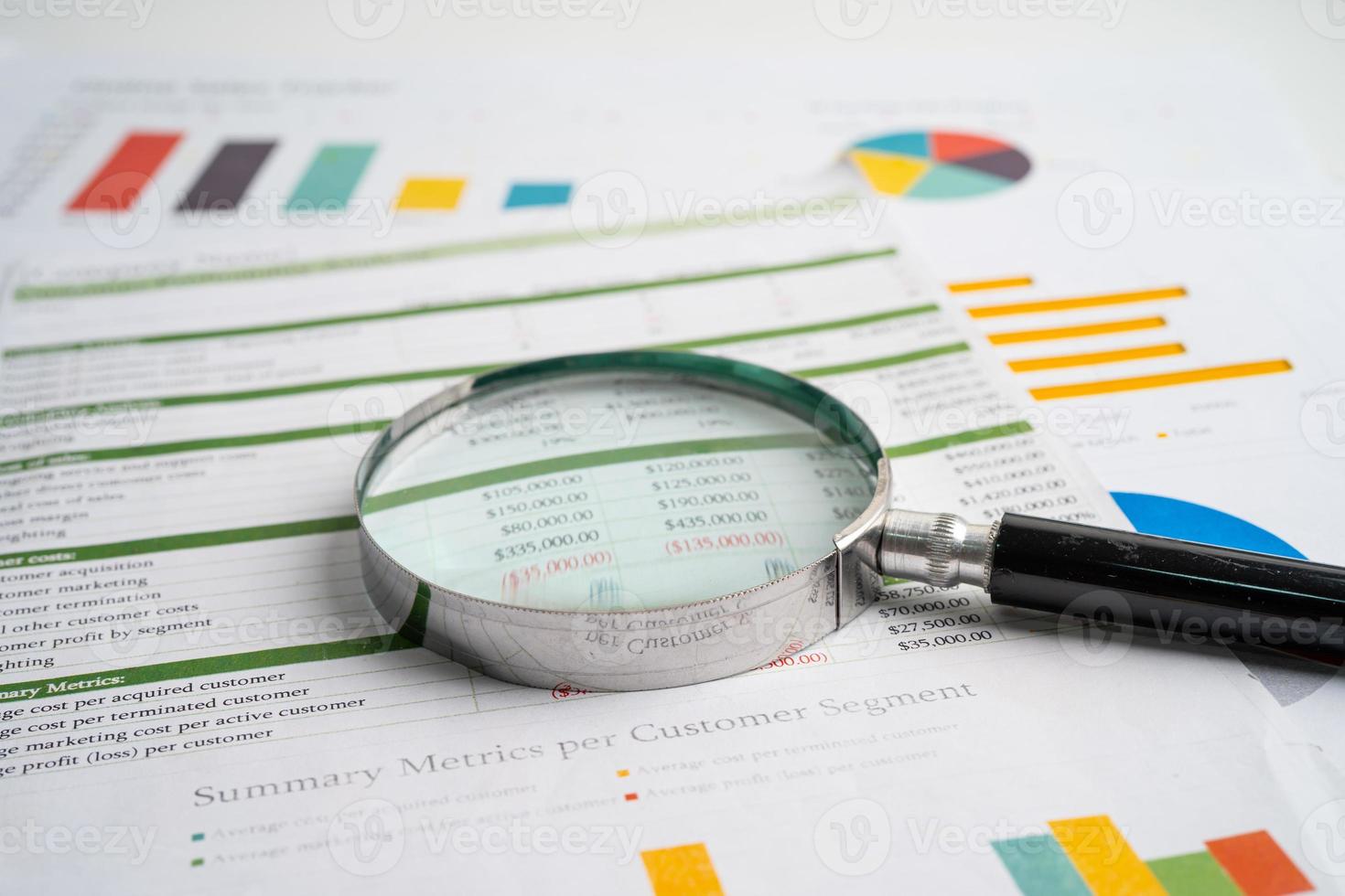 Magnifying glass on charts graphs paper. Financial development, Banking Account, Statistics, Investment Analytic research data economy, Stock exchange trading, Business office concept. photo