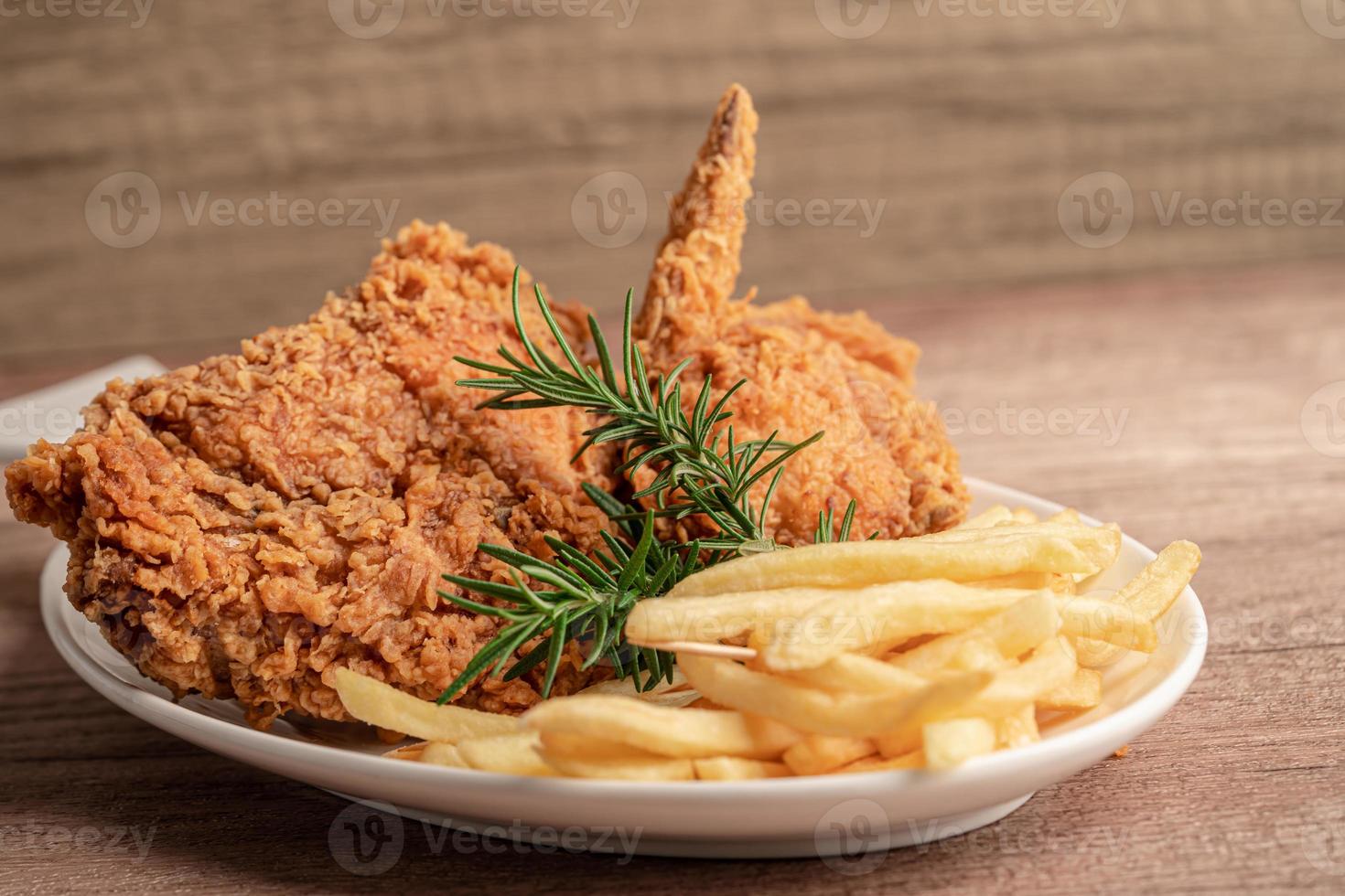 Fried chicken and potato chip with rosemary leaf, Junk food high calorie served on white plate photo