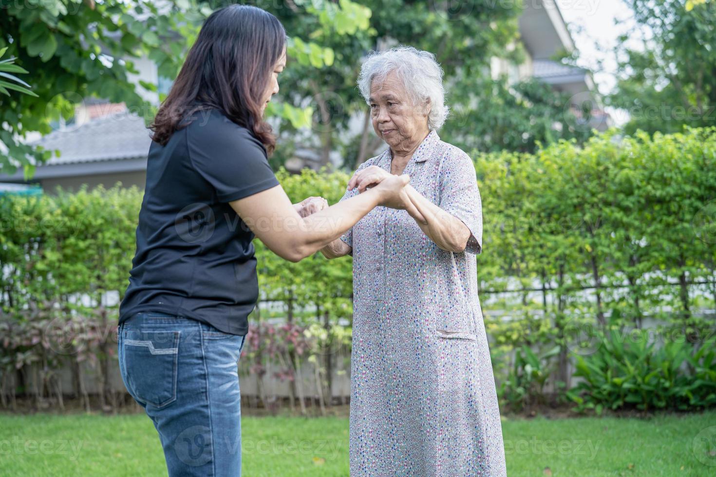 Asian elderly woman with caregiver daugther walking  with happy in nature park. photo