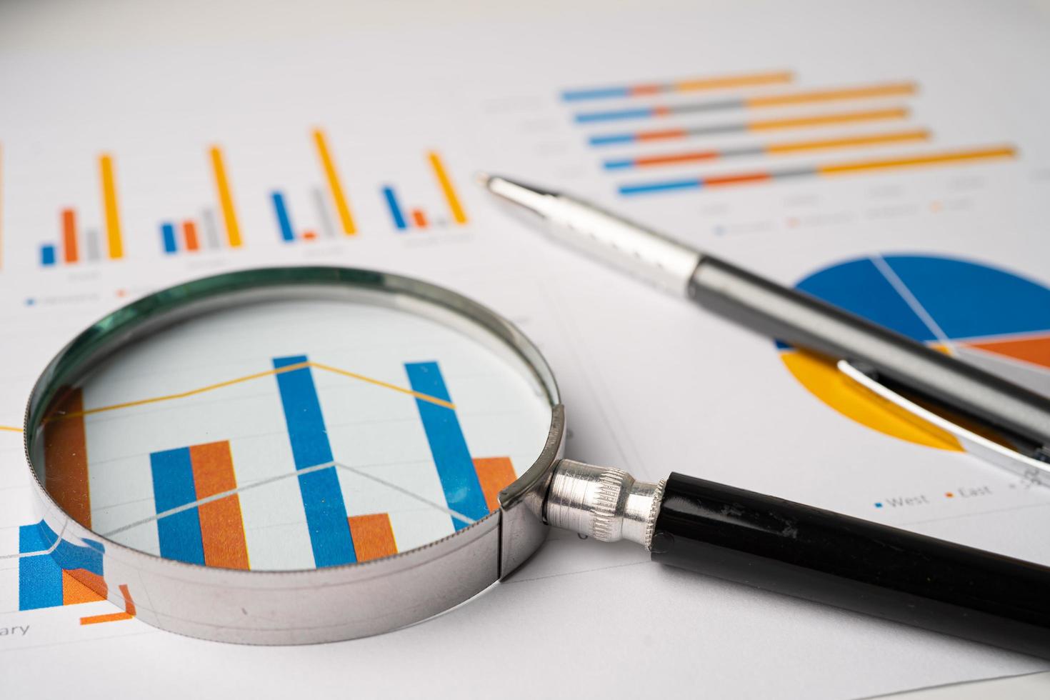 Magnifying glass on charts graphs paper. Financial development, Banking Account, Statistics, Investment Analytic research data economy, Stock exchange trading, Business office company meeting concept. photo