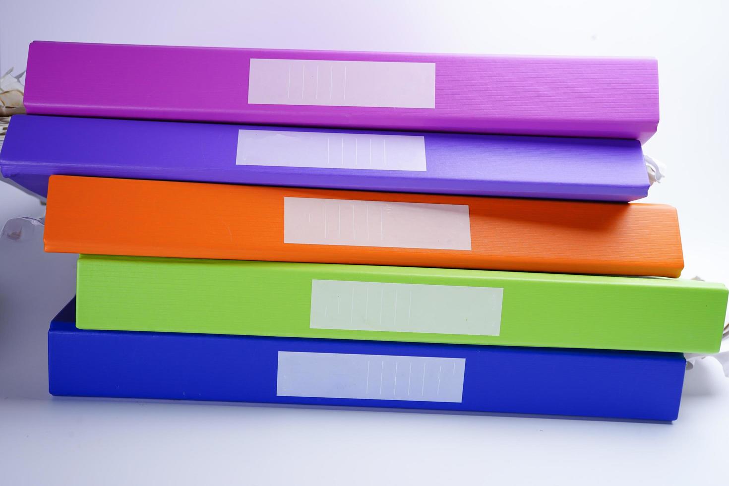 File Folder Binder stack of multi color on table in office. photo