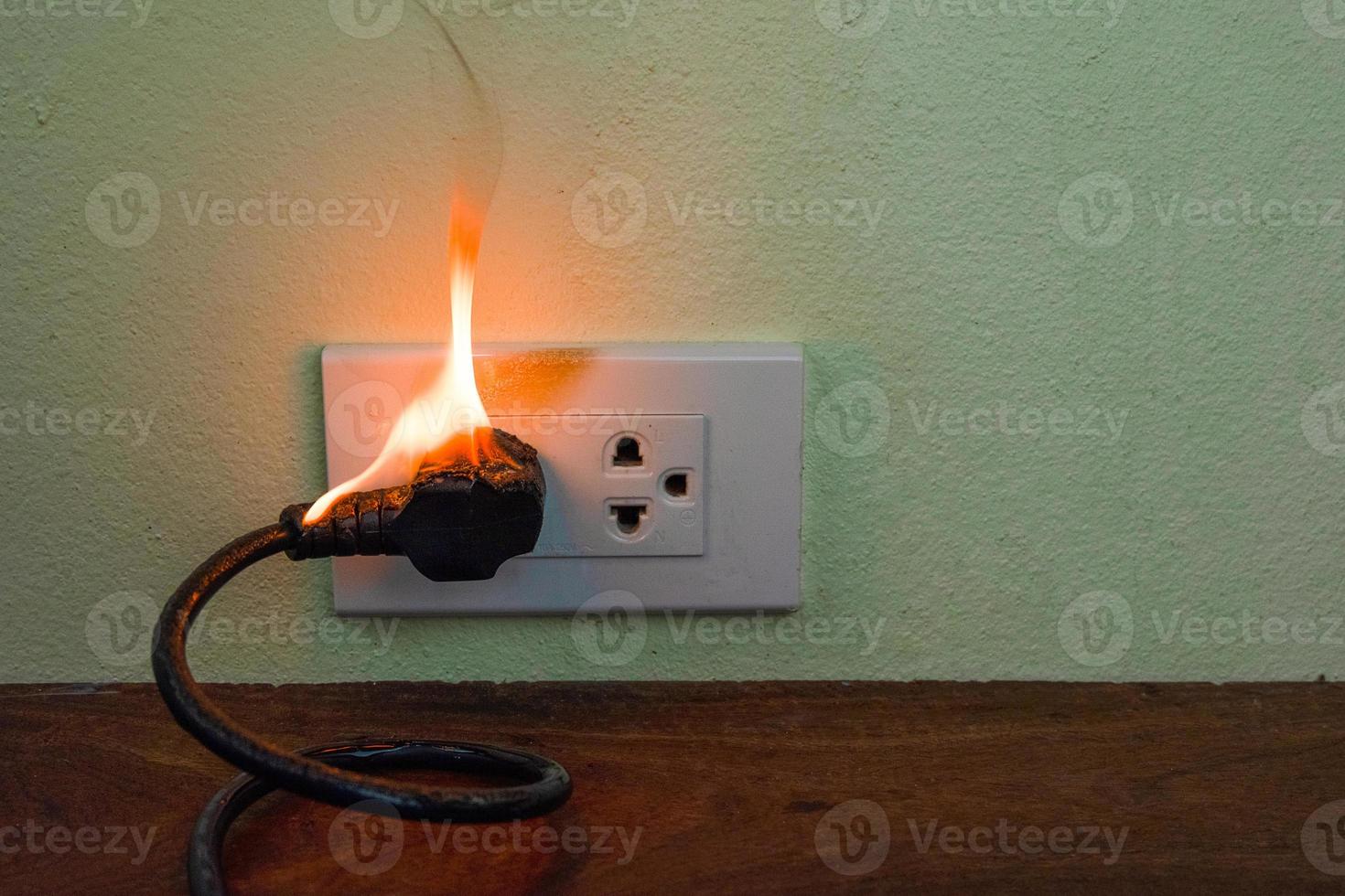 en la pared del receptáculo del enchufe del cable eléctrico del fuego foto