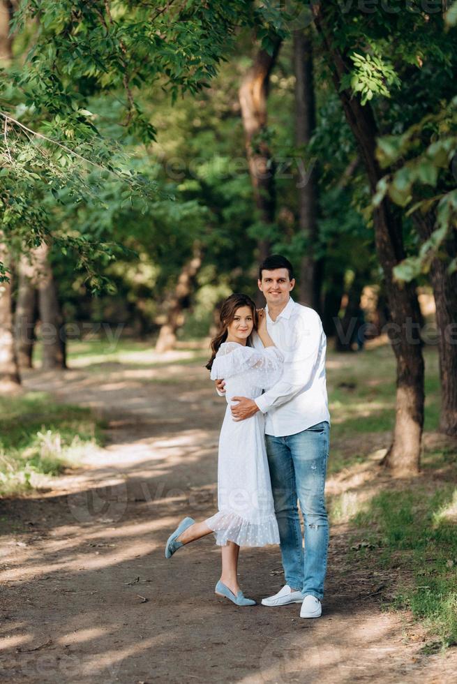 guy and a girl walk along the paths of a forest park photo