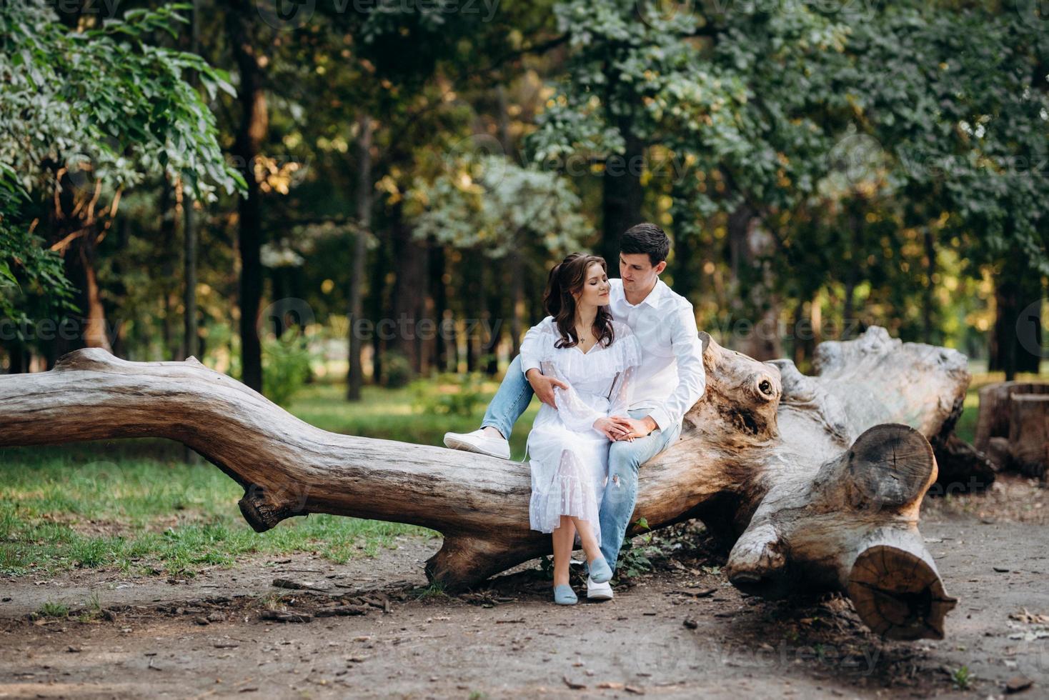 guy and a girl walk along the paths of a forest park photo