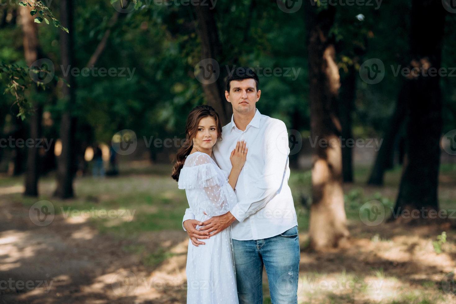 guy and a girl walk along the paths of a forest park photo