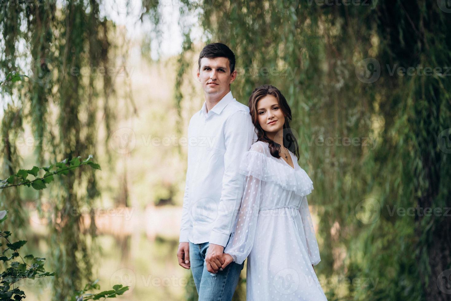guy and a girl walk along the paths of a forest park photo