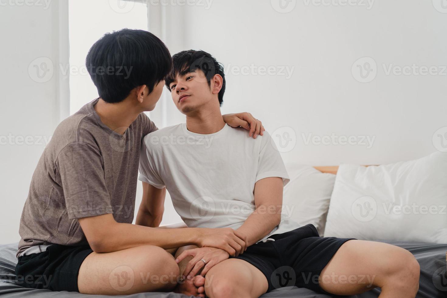 Asian Gay couple kissing on bed at home. Young Asian LGBTQ men happy relax rest together spend romantic time after wake up in bedroom at home in the morning concept. photo