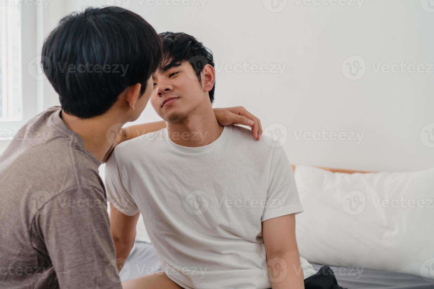 pareja gay asiática besándose en la cama en casa. jóvenes asiáticos lgbtq hombres felices relajarse descansar juntos pasar un momento romántico después de despertarse en el dormitorio en casa en el concepto de la mañana. foto