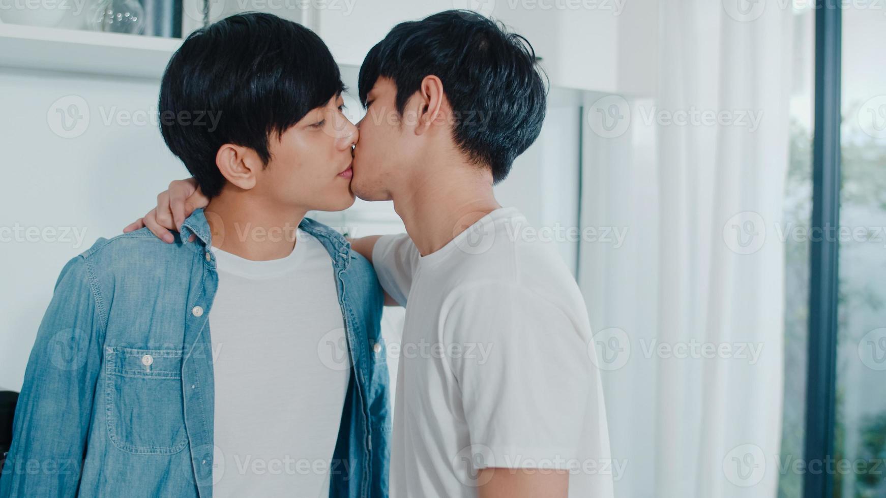 Asian Gay couple standing and hugging room at home. Young handsome LGBTQ men kissing happy relax rest together spend romantic time in modern kitchen at house in the morning concept. photo