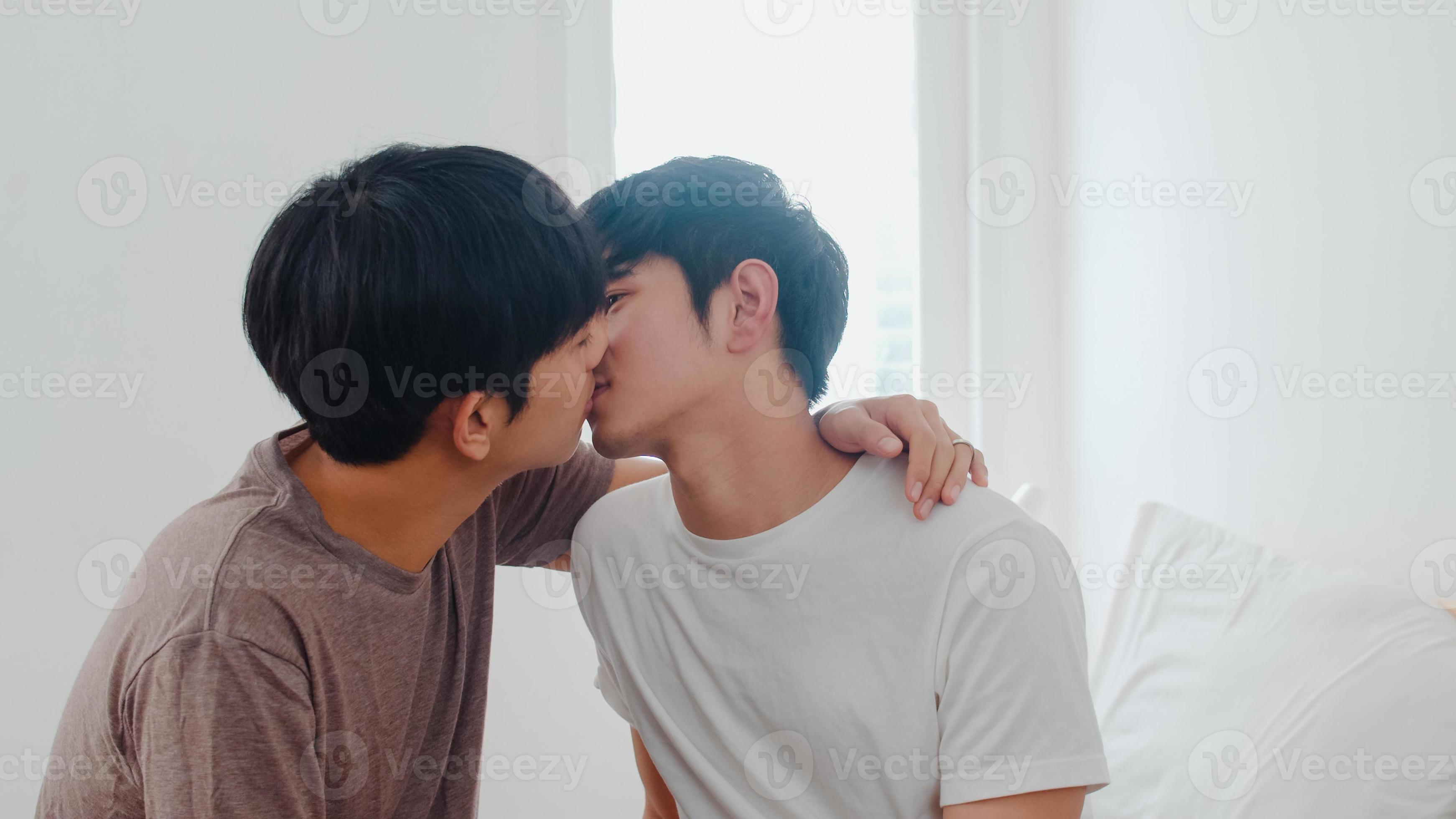 Asian Gay couple kissing on bed at home image