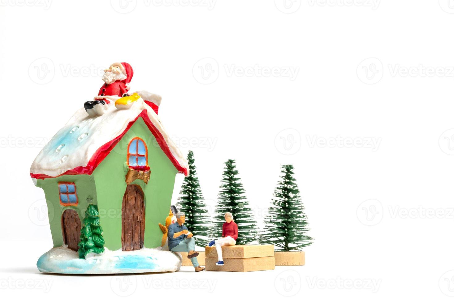 Miniature people celebrating Christmas at home photo