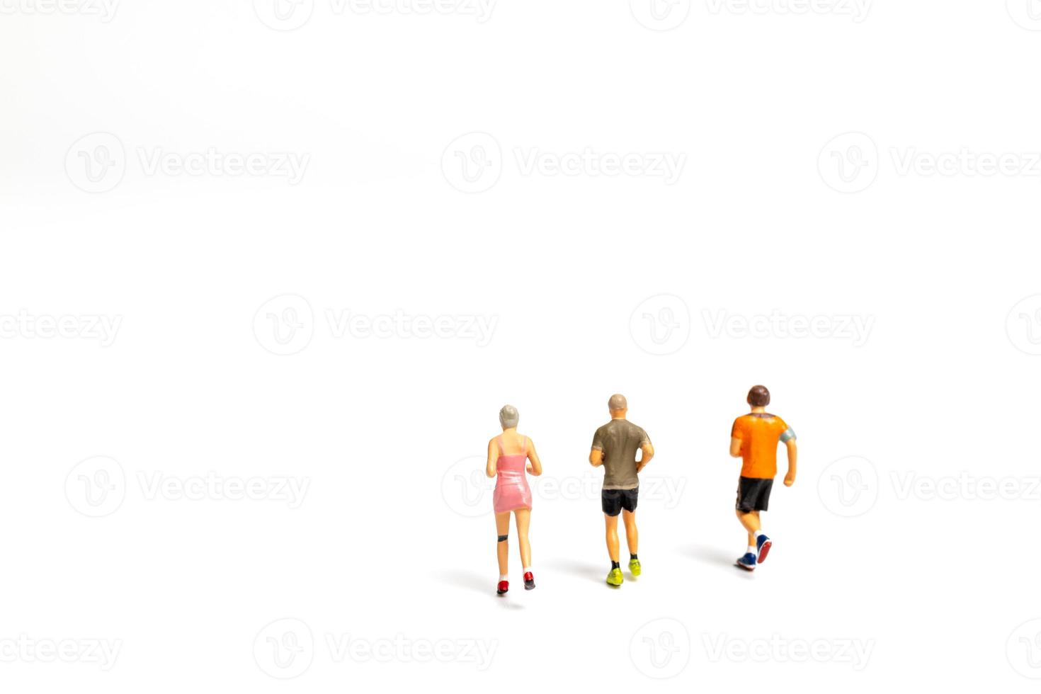 Miniature people running on white background photo