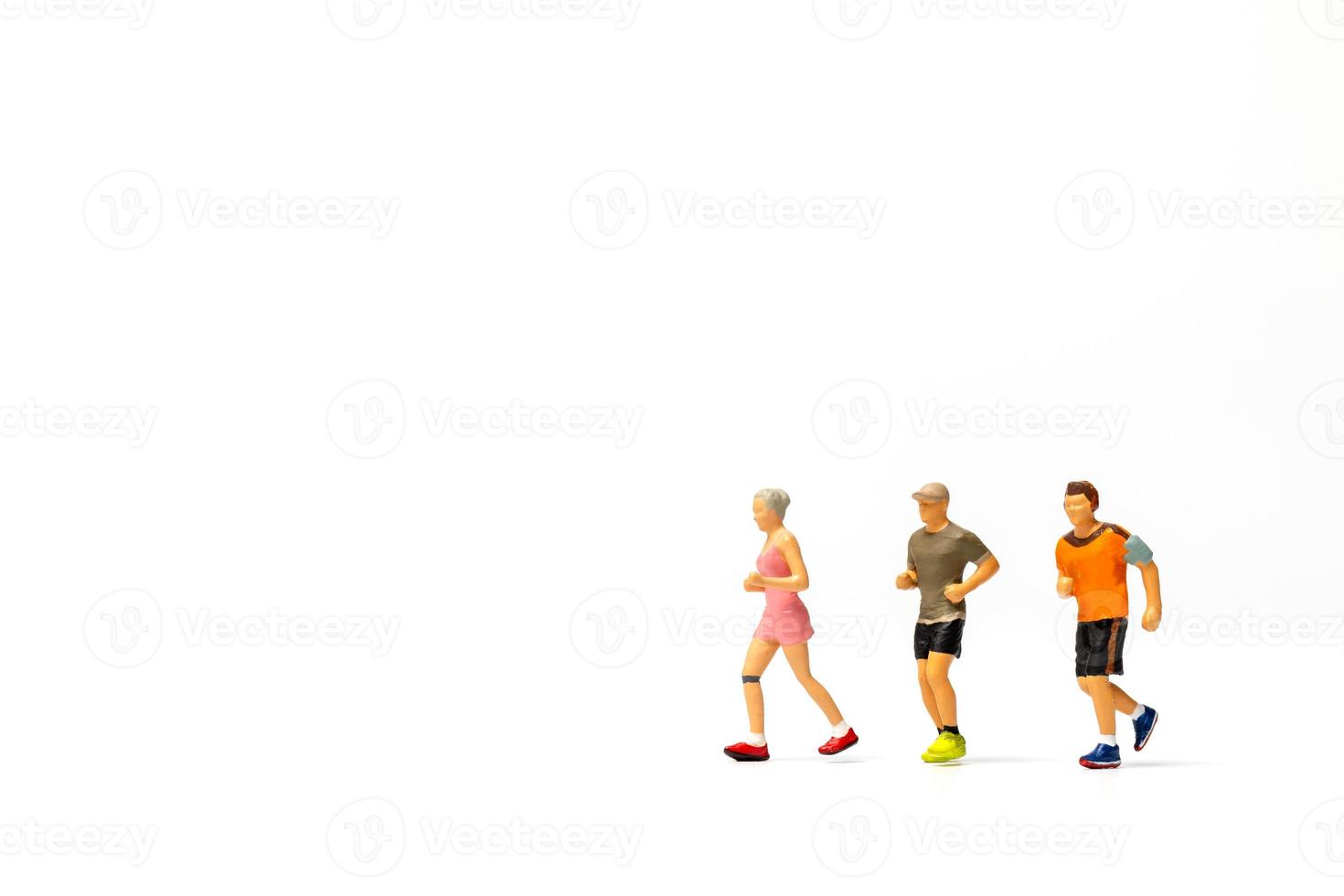 Miniature people running on white background photo