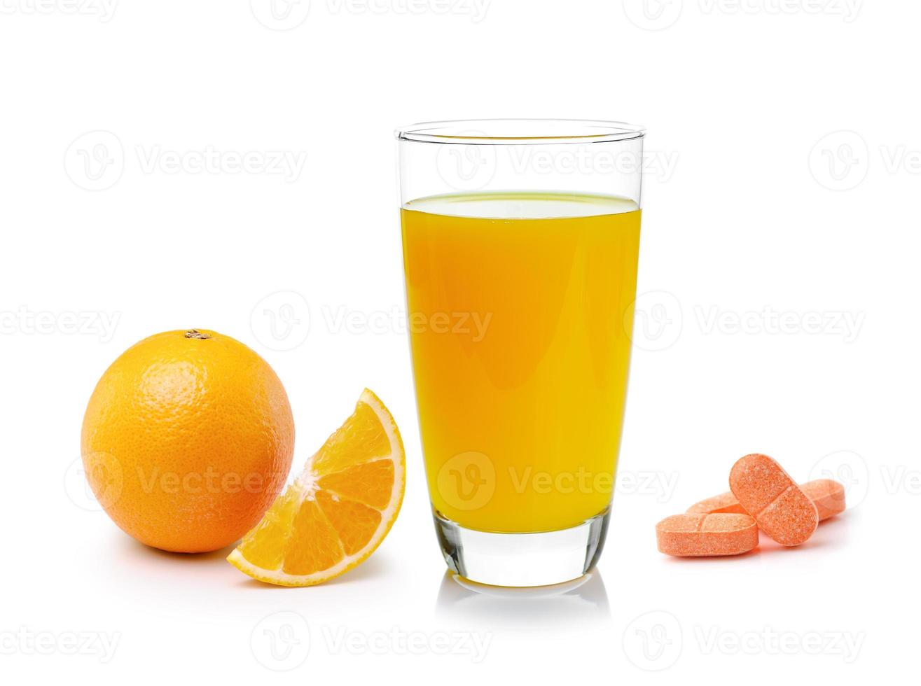 Jugo de naranja en vidrio, fruta naranja con tableta de vitamina C sobre fondo blanco. foto