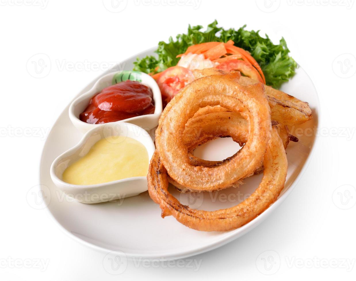 Aros de cebolla en un plato sobre fondo blanco. foto