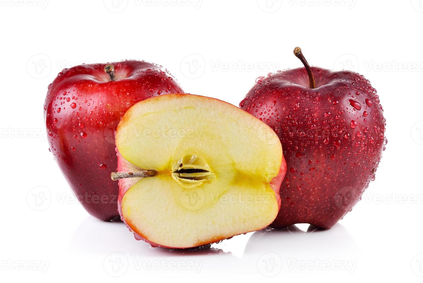 Manzana roja con gotas de agua sobre fondo blanco. foto