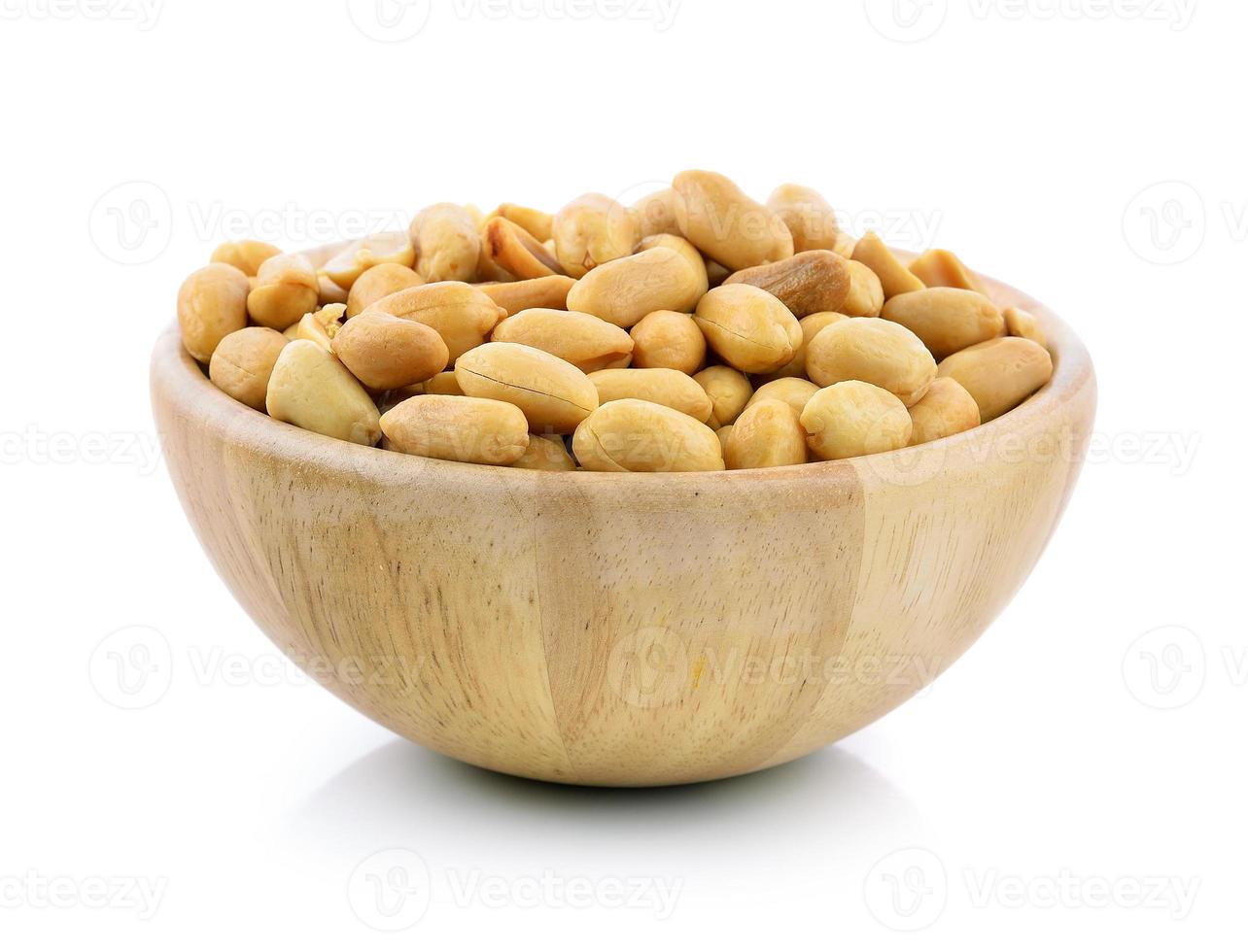 peanuts in a wood bowl on white background photo
