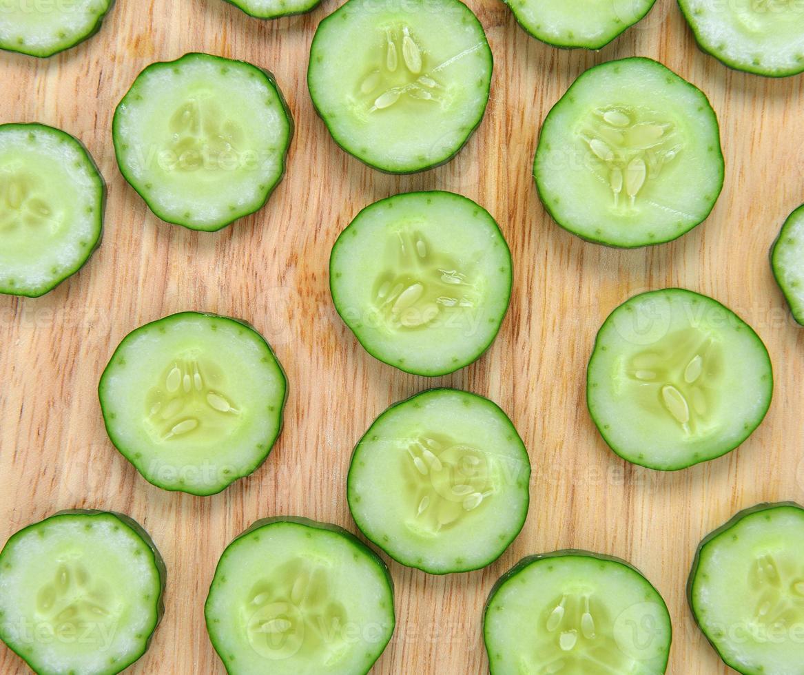 Pepino fresco y rodajas de madera foto