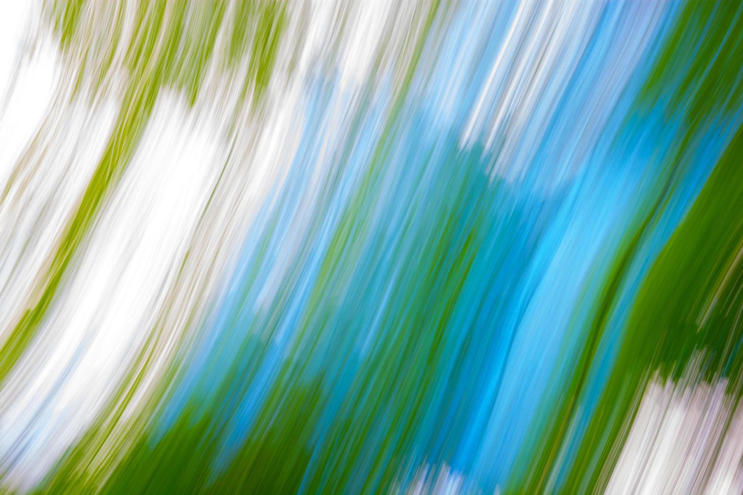 Abstract blurred background of green leaves and blue sky with highlights. photo