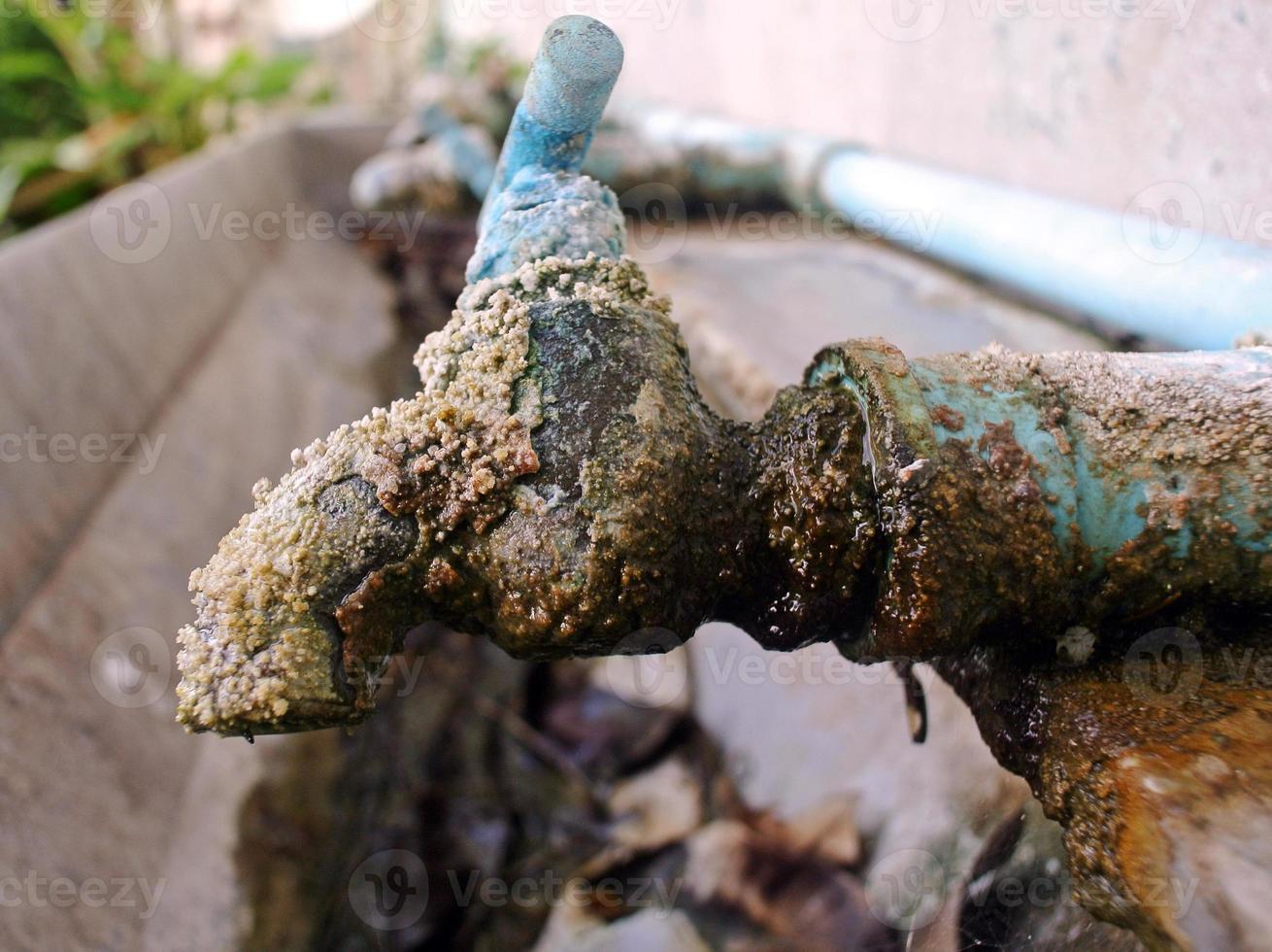 old rusty tap leaking water photo