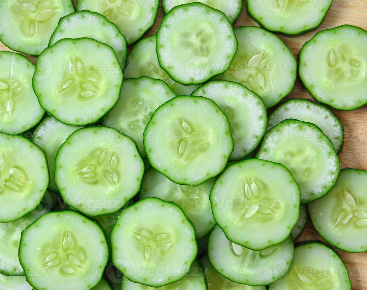 Pepino fresco y rodajas de fondo blanco. foto