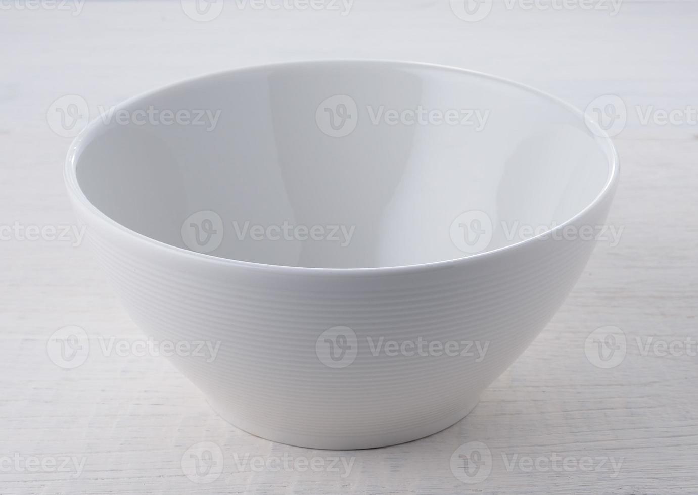 Empty white ceramic bowl on white wood photo