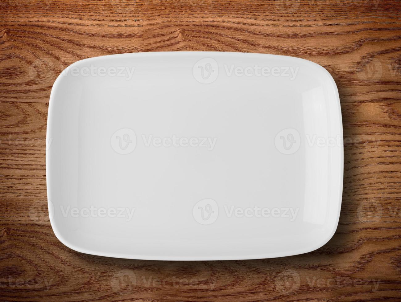 Empty white plate on wooden table photo