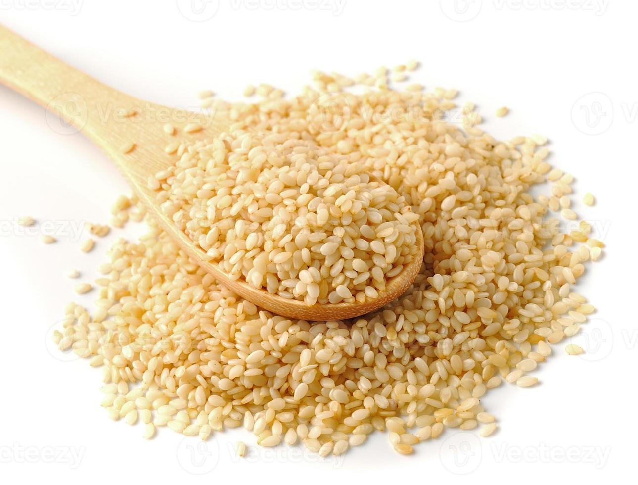 Wooden spoon with sesame seeds on a white background photo
