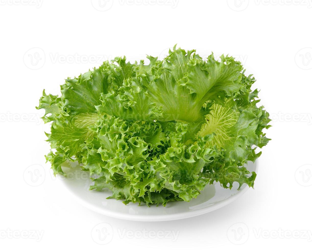 Lechuga en el plato blanco aislado sobre fondo blanco. foto