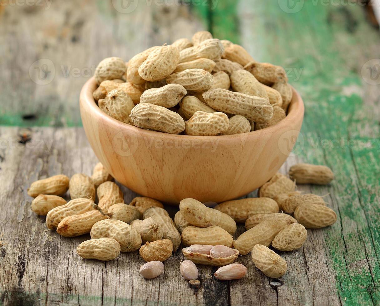 peanuts in a wood bowl on a wooden table photo