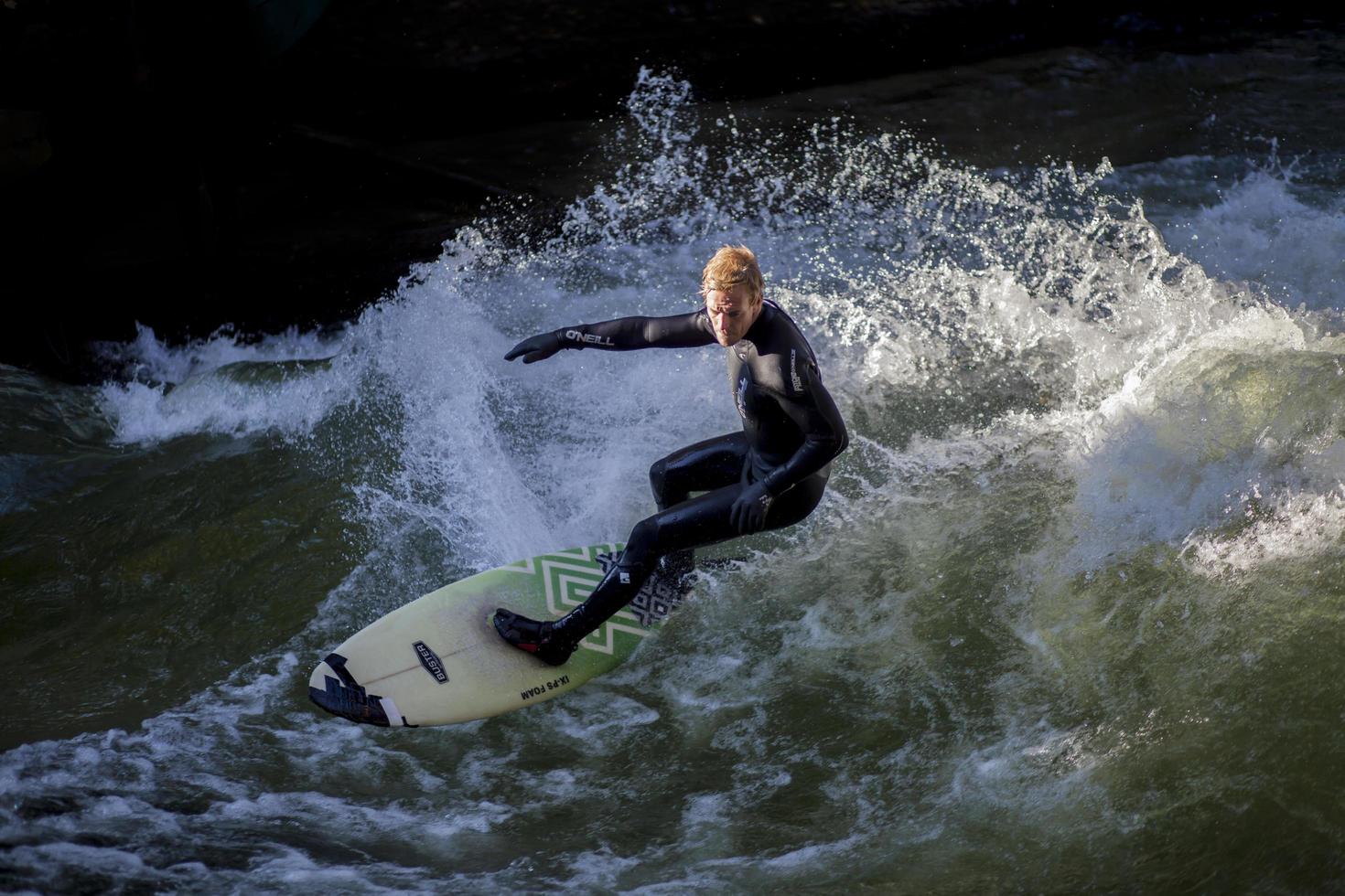 munich, alemania, 23 de octubre - surfista no identificado en el río eisbach en el jardín inglés en munich, alemania, el 23 de octubre de 2011. los primeros surfistas descubrieron el eisbach en la década de 1970. foto