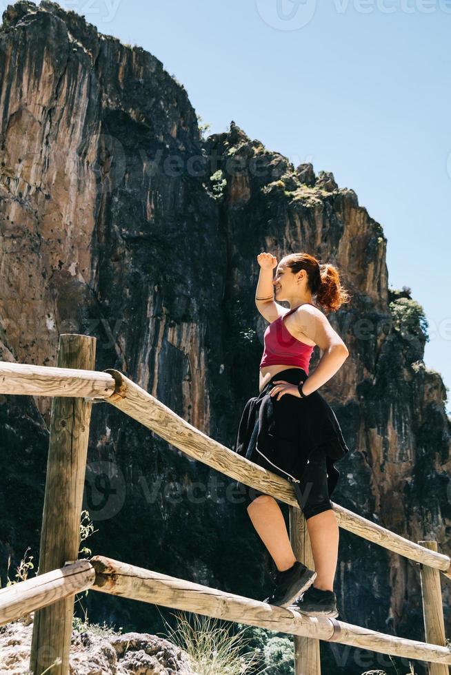 Happy young woman hiker watching the landscape photo