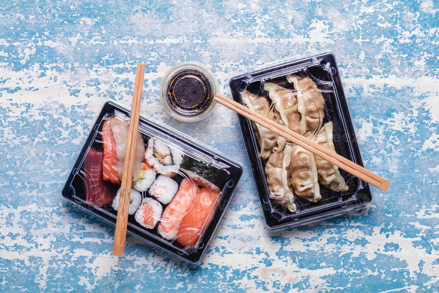 Sushi to go concept. Takeaway box with assorted sushi and gyoza photo