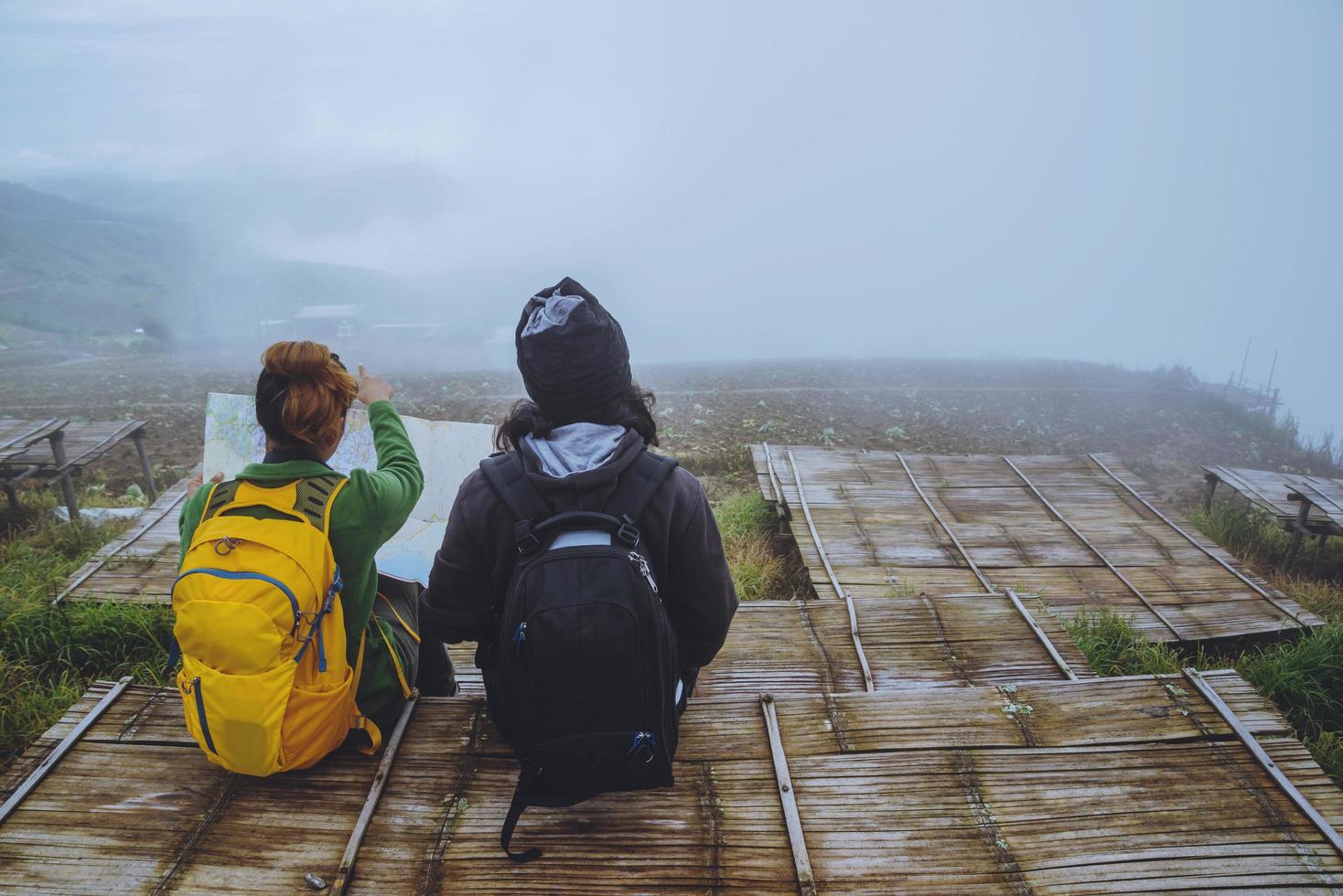 amantes mujeres y hombres asiáticos viajar relajarse en las vacaciones. ver mapa explorar las montañas foto