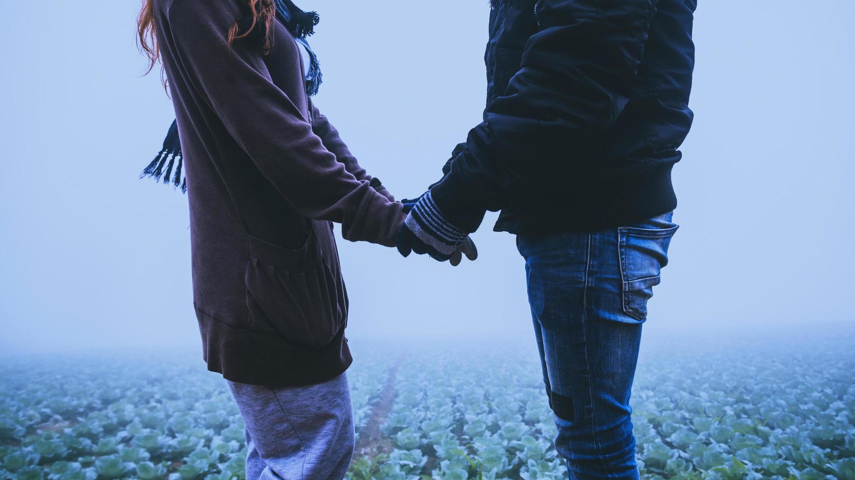 amantes mujeres y hombres asiáticos viajar relajarse en las vacaciones. feliz de viajar en las vacaciones. los amantes caminan de la mano durante el invierno brumoso foto