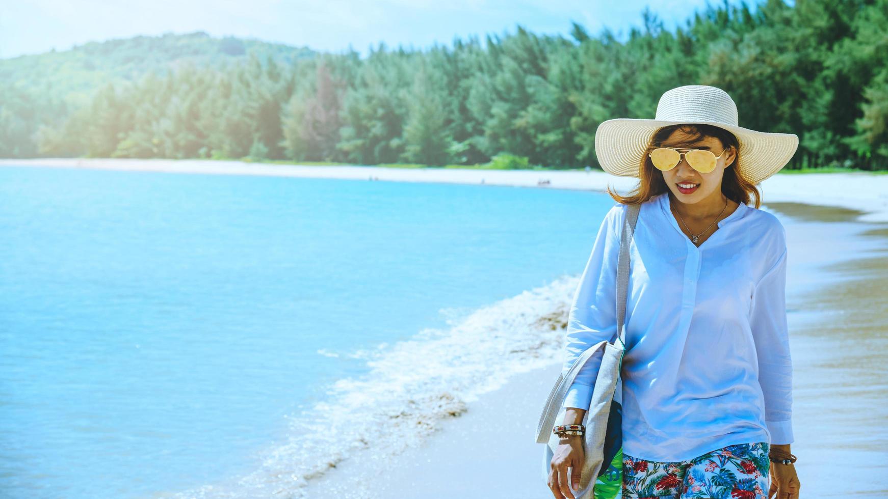 las mujeres asiáticas viajan por la naturaleza. viajar relajarse. jugar agua de mar en la playa. en el verano. tailandia foto