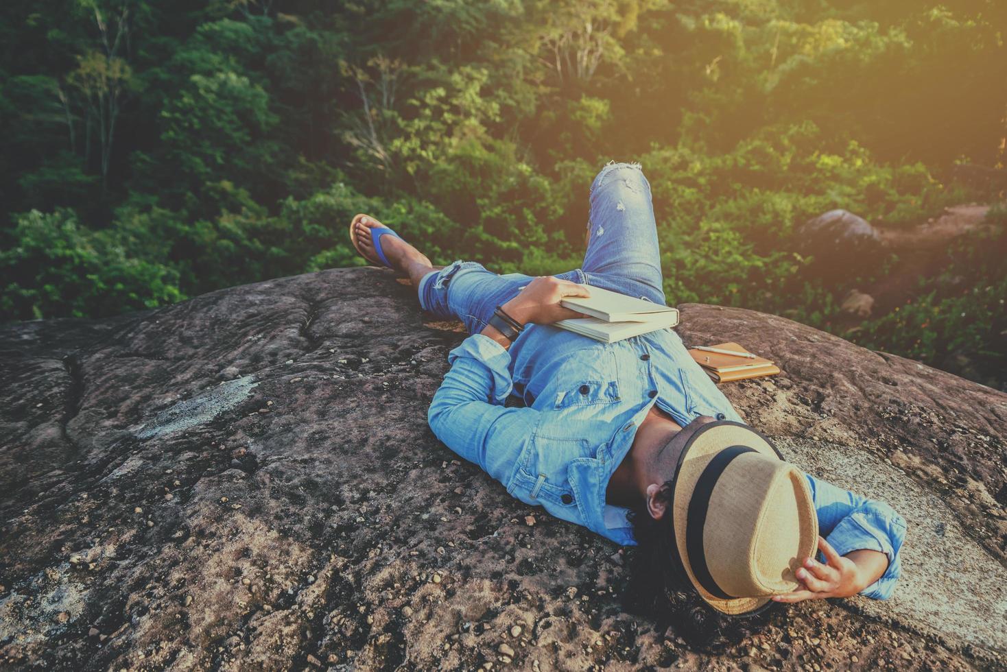 Asian man travel relax in the holiday. sleep relax read books on rocky cliffs. On the Moutain. In Thailand photo