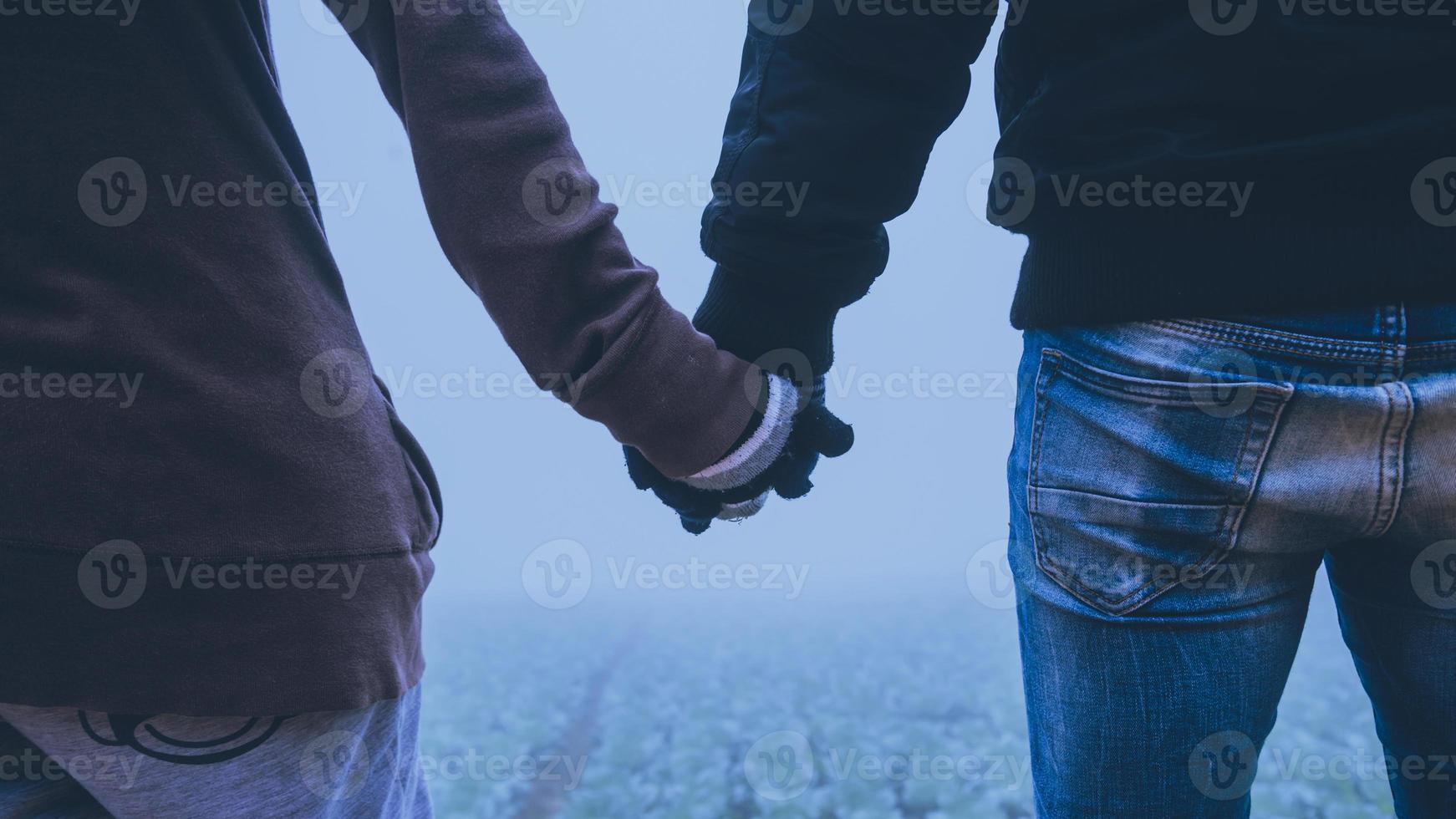 amantes mujeres y hombres asiáticos viajar relajarse en las vacaciones. feliz de viajar en las vacaciones. los amantes caminan de la mano en el campo de arroz. durante el invierno brumoso foto