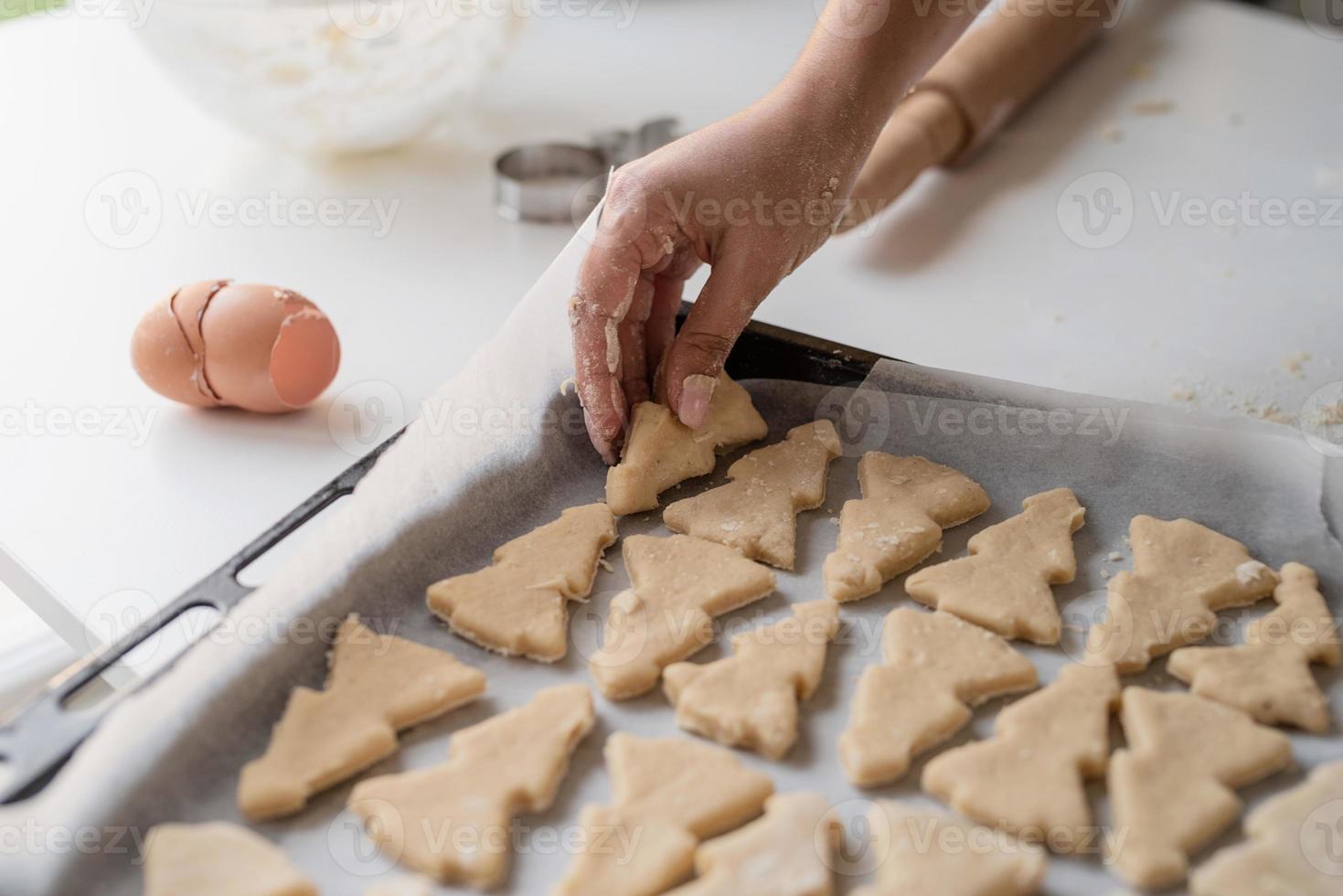 Mujer sonriente en la cocina para hornear galletas de Navidad foto