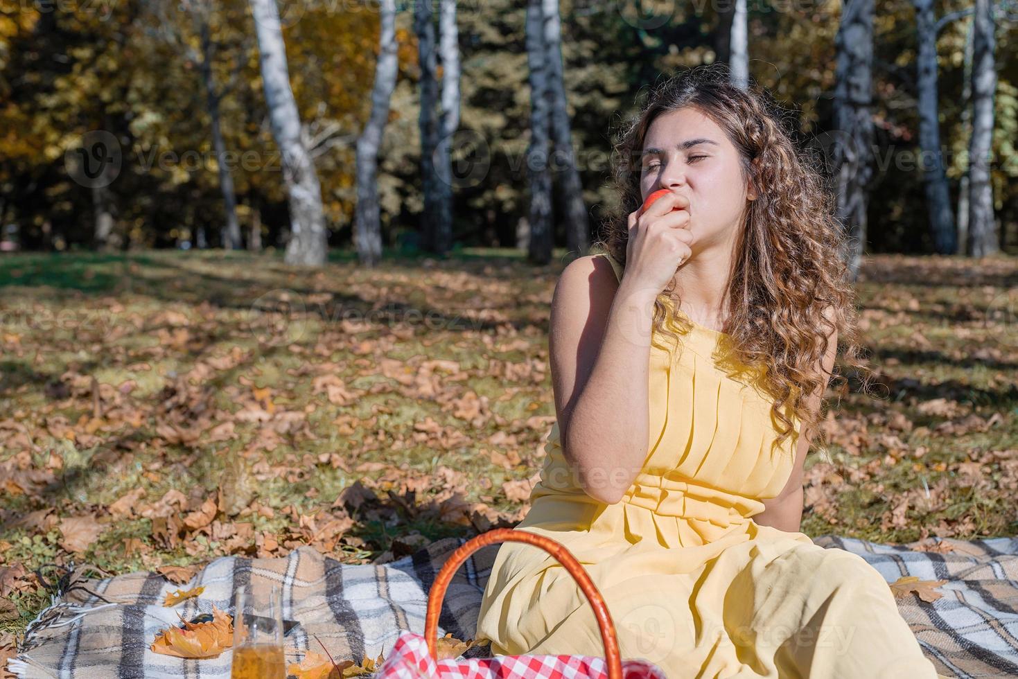 Bella mujer en vestido amarillo en un picnic foto