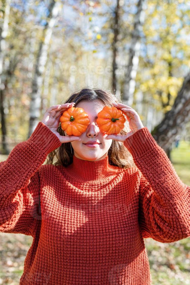 Beautiful woman in red sweater on a picnic in a autumn forest photo