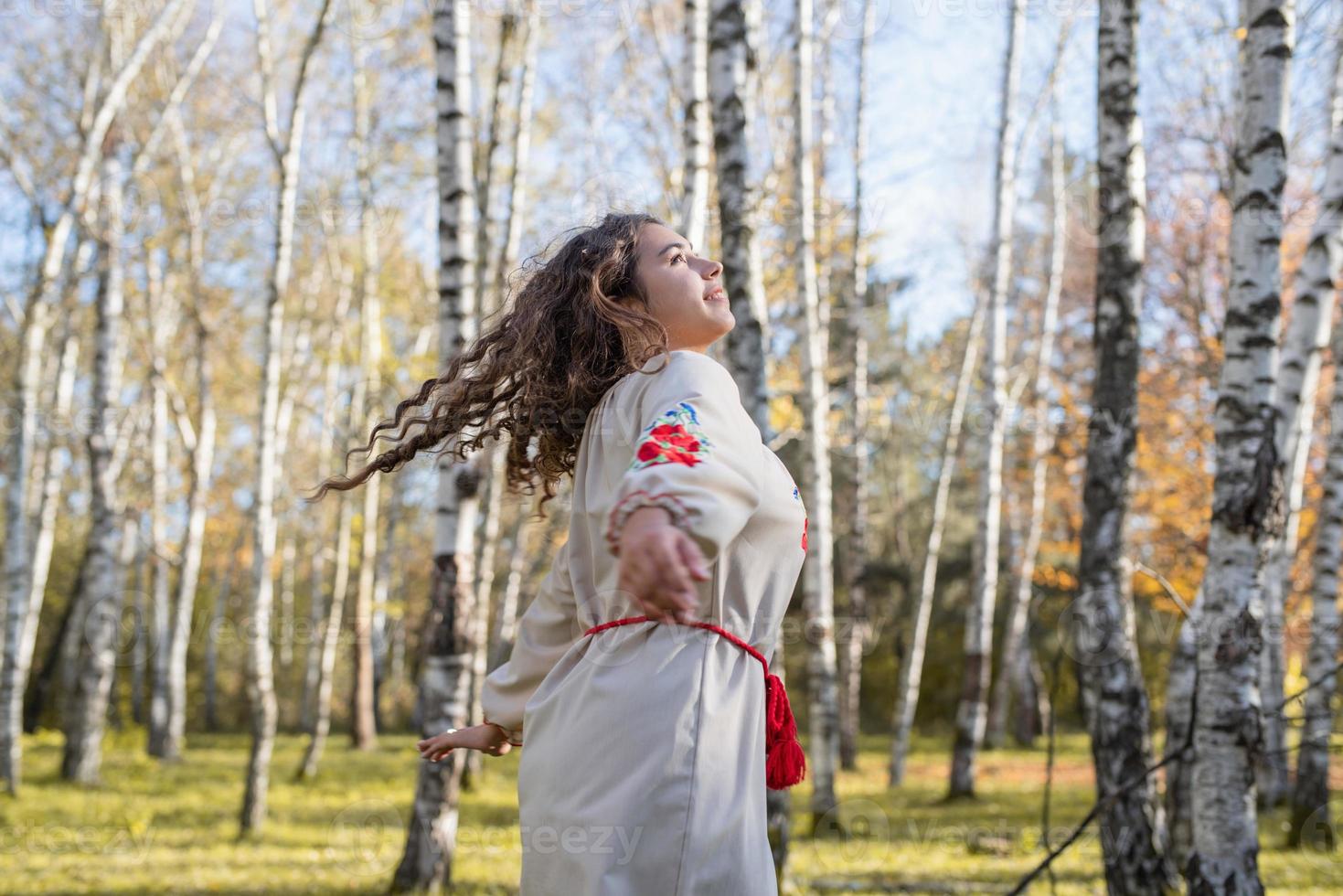 Bella mujer en traje tradicional nacional ucraniano ropa bailando en el bosque foto