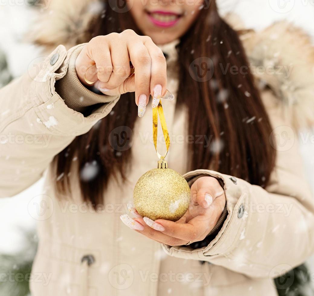 Beautiful woman in warm winter clothes holding christmas decatation photo