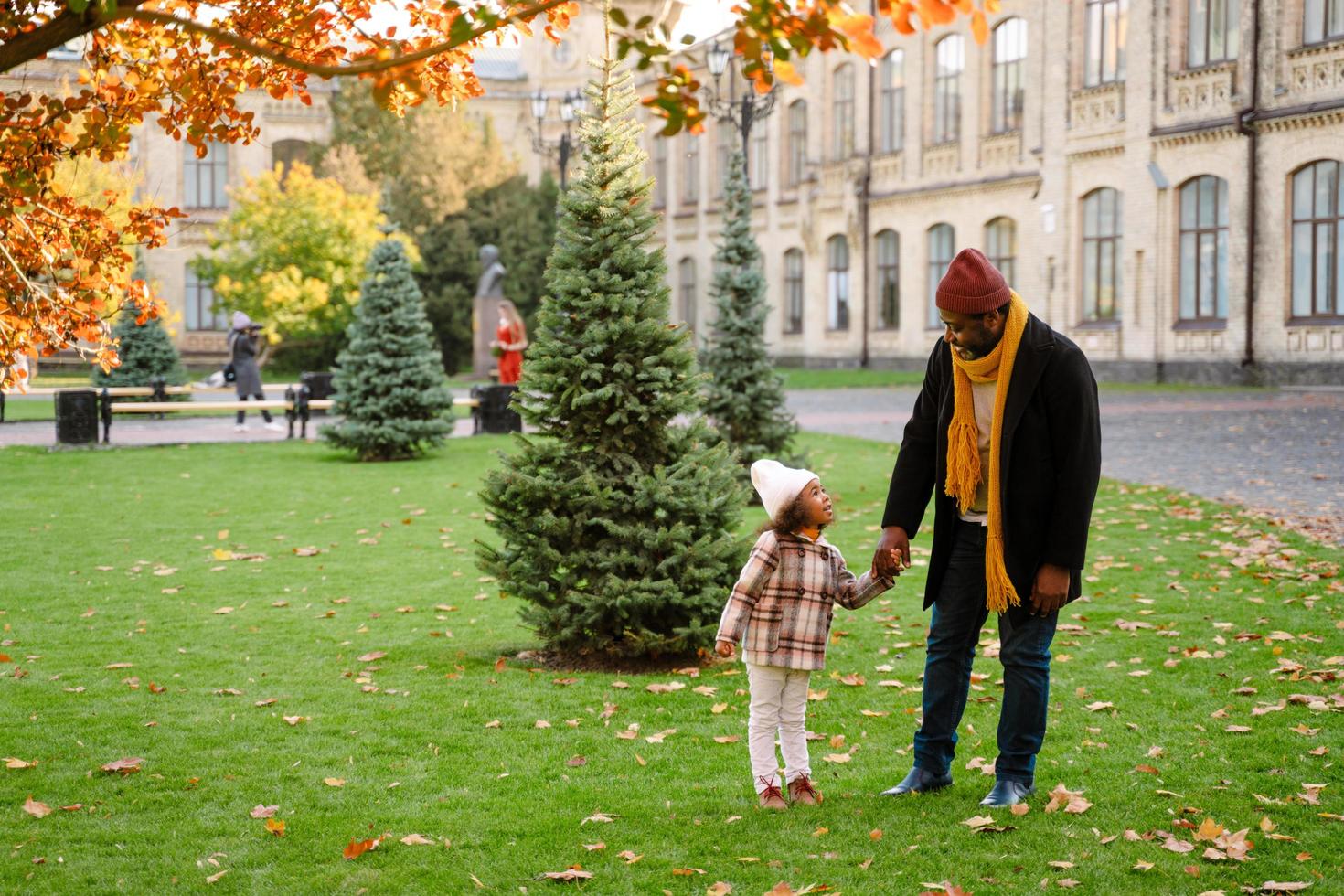 Black grandfather talking with his granddaughter while walking outdoors photo