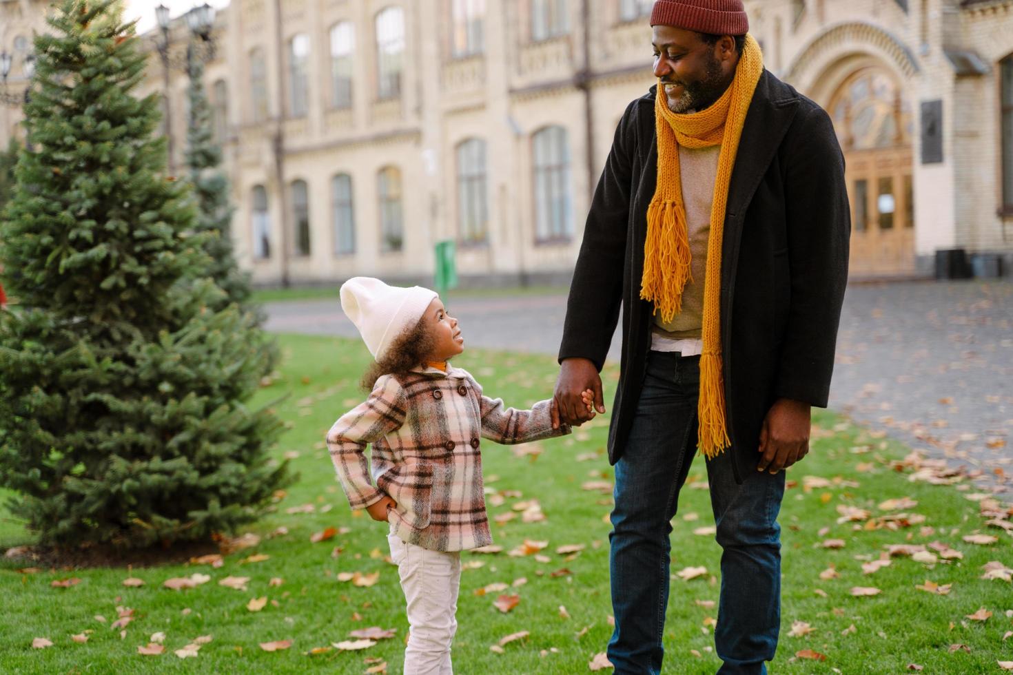 Black grandfather talking with his granddaughter during outdoor walk photo