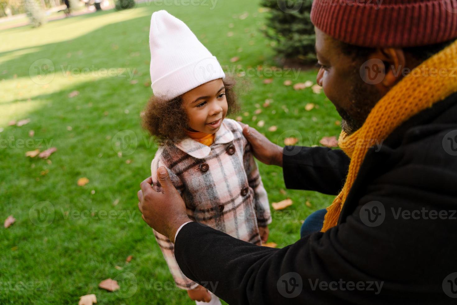 Black grandfather talking with his granddaughter during a walk outdoors photo