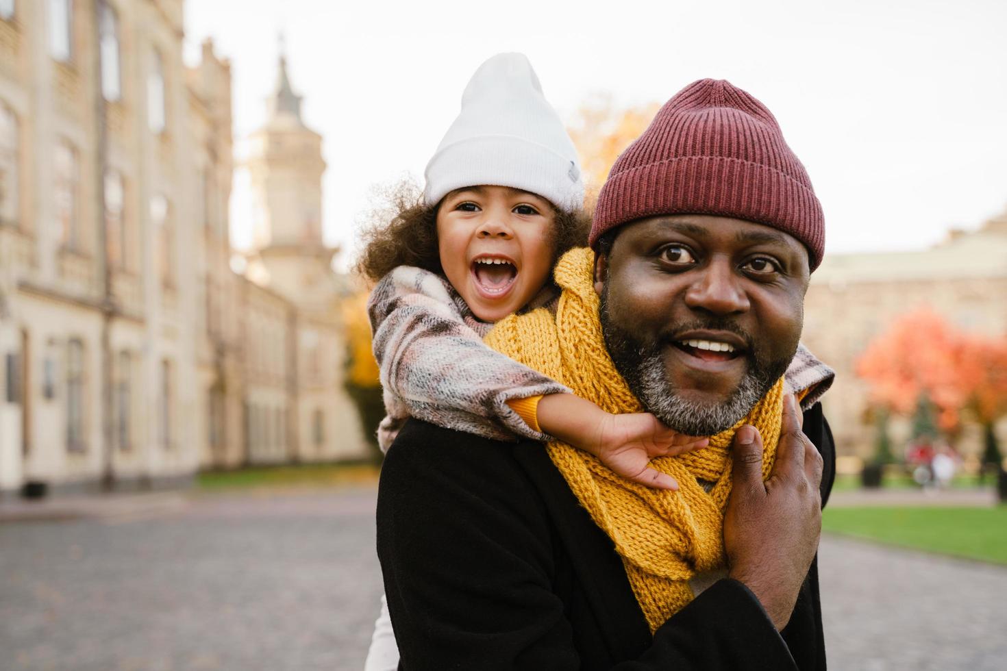 Black grandfather talking with his granddaughter while walking outdoors photo