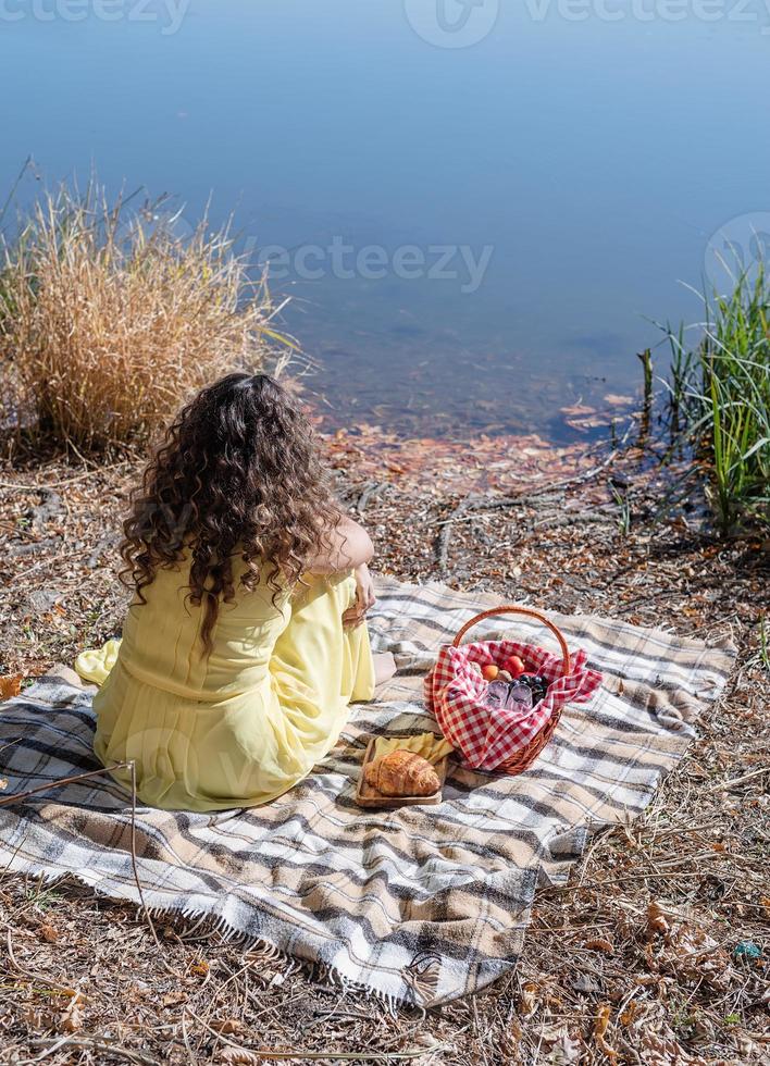 Bella mujer en vestido amarillo en un picnic foto