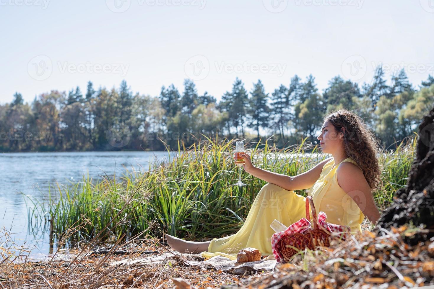 Bella mujer en vestido amarillo en un picnic foto