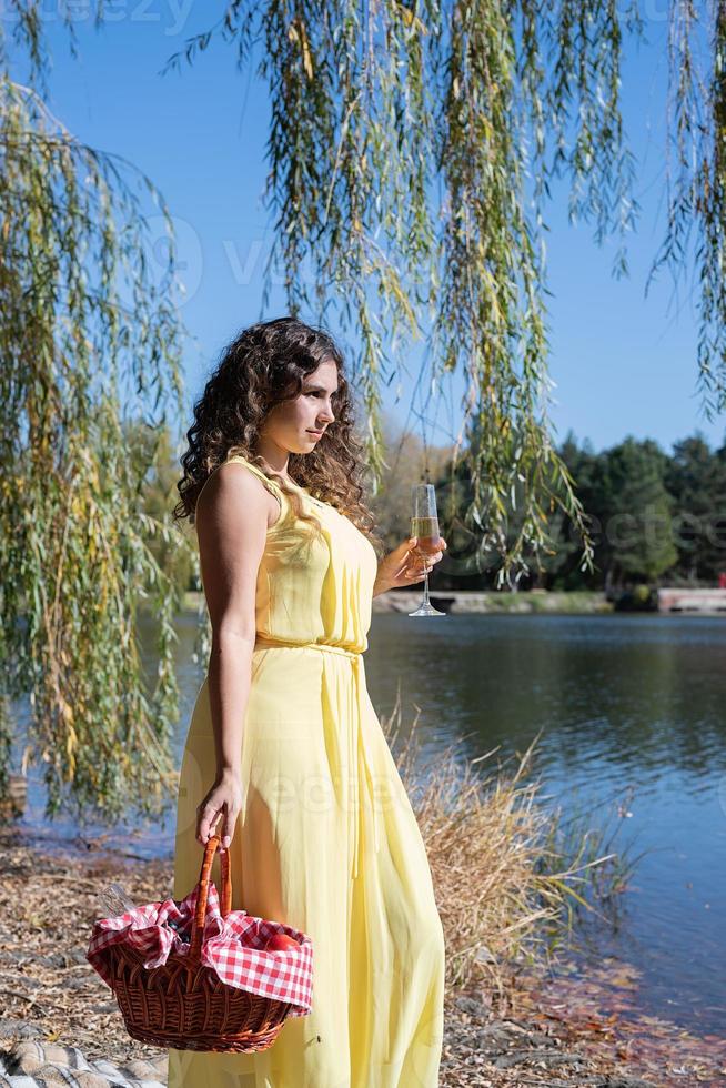 Bella mujer en vestido amarillo en un picnic foto